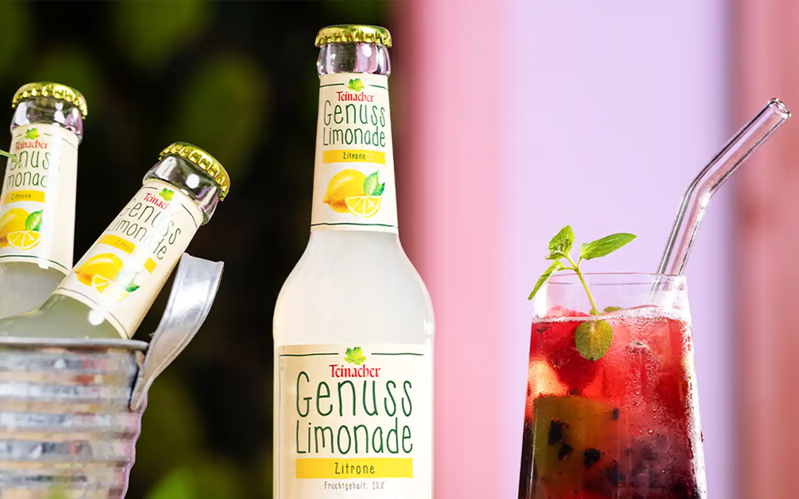 Nahaufnahme der Teinacher Genusslimonade Zitrone in Flasche und Glas Virgin Berry Lemon mit frischen Beeren und Minze.