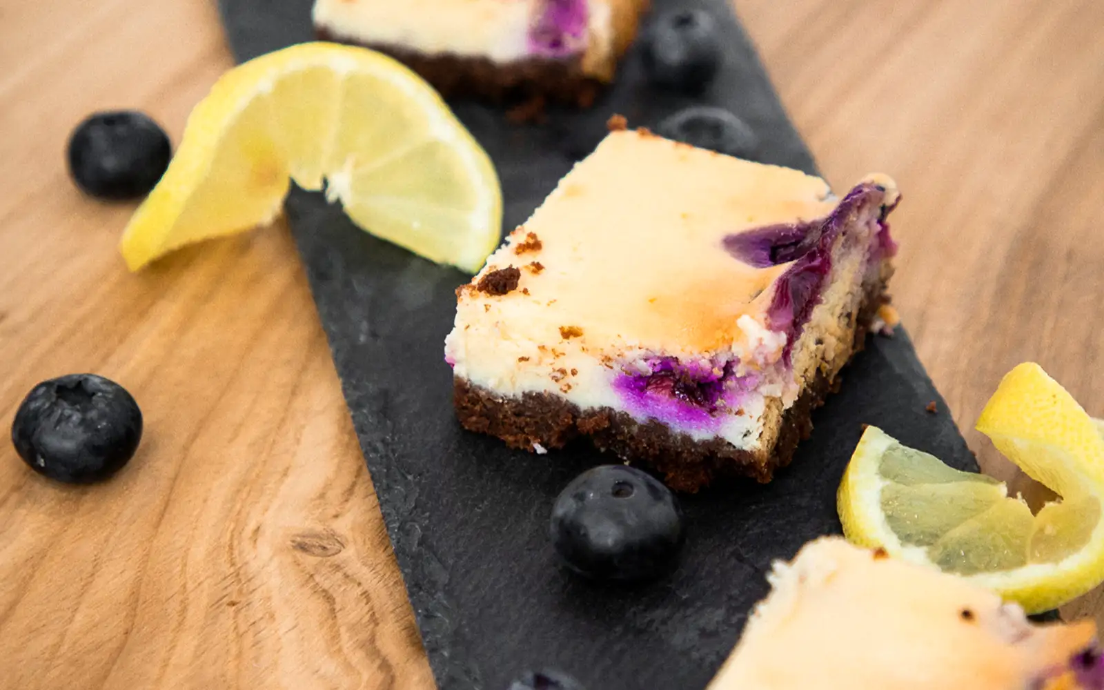 Zitronen-Blaubeeren-Käsekuchen auf einem Holzbrett von Oben