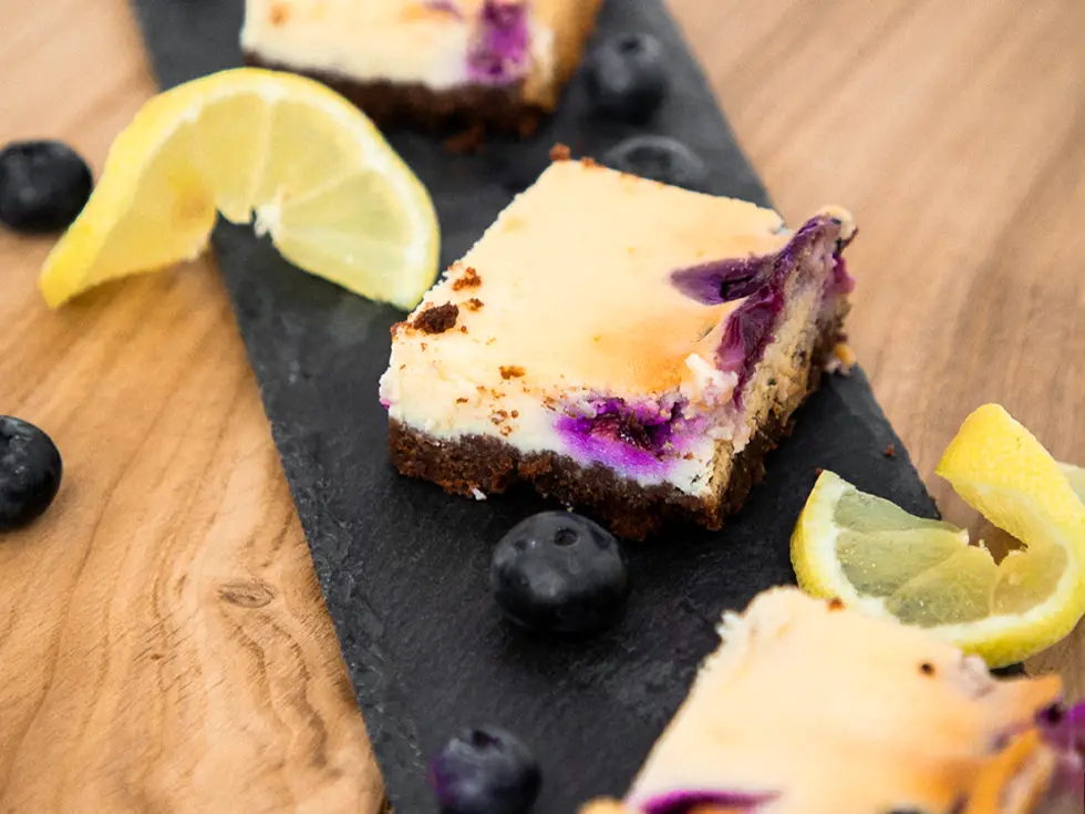 Zitronen-Blaubeeren-Käsekuchen auf einem Holzbrett von Oben