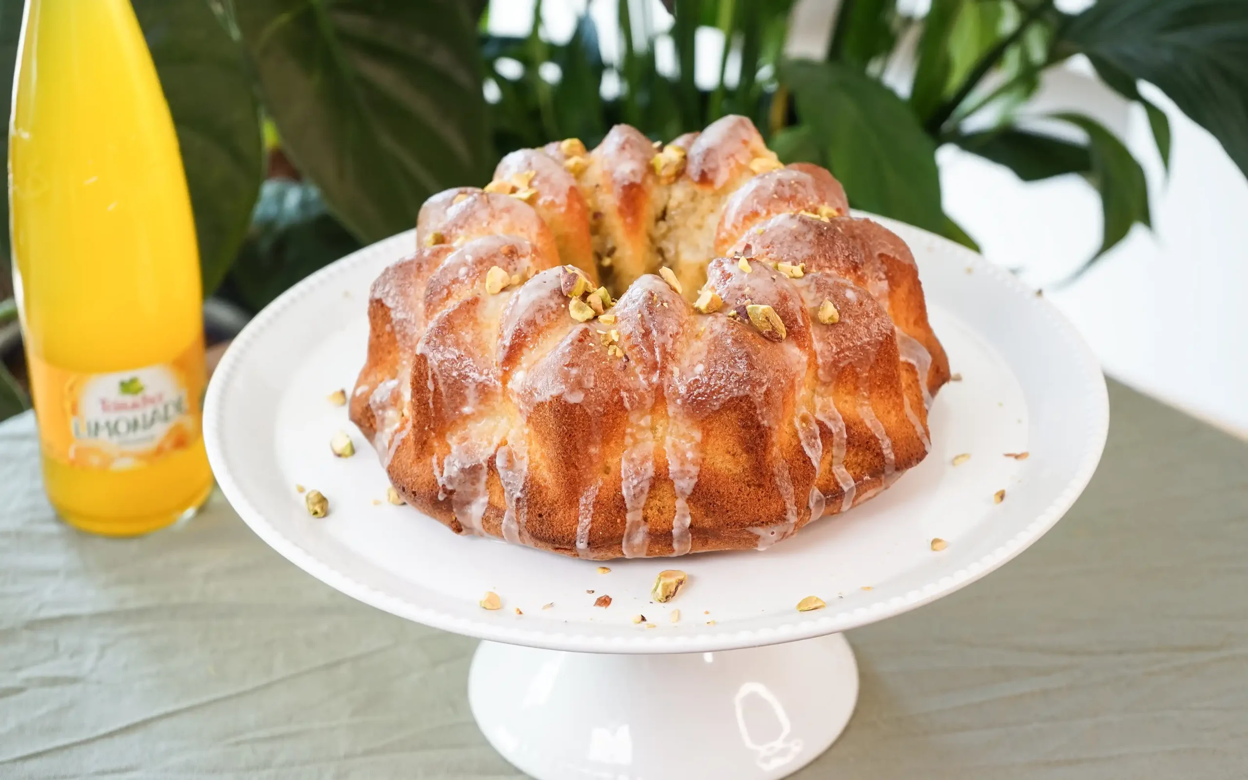 Teinacher Longneck Flaschen Genuss-Limonade Mango-Maracuja-Orange mit 2 Gläsern gefüllt mit Eiswürfeln und Früchten